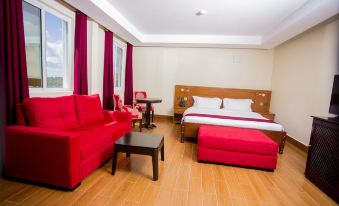 a modern hotel room with a red couch , wooden table , and bed , along with other furniture at Hotel San Marino