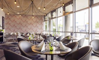 a dining room with several tables and chairs , some of which are covered in black tablecloths at Hôtel Mercure Paris Ivry Quai de Seine