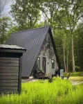 A modern A-frame, nestled in the woods with relaxing outdoor spaces and firepit.