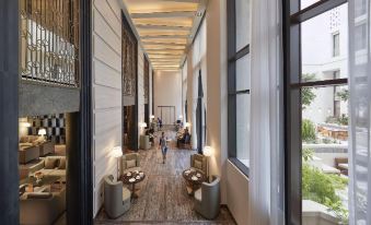 a modern , spacious living room with high ceilings and large windows , featuring comfortable seating arrangements and a dining area at Mandarin Oriental, Doha