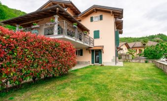 a house surrounded by green grass and bushes , with a beautiful view of the surrounding area at Federica