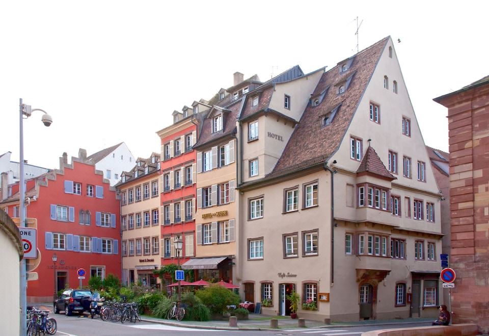 a city street with a mix of old and modern architecture , including a row of buildings with red roofs at Hotel Suisse