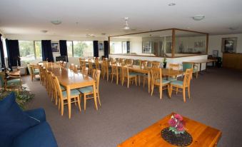 a large dining room with multiple tables and chairs arranged for a group of people to enjoy a meal together at The Lodge