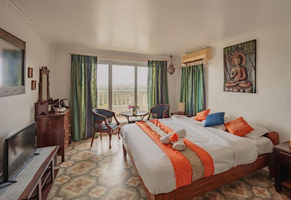 a spacious bedroom with a large bed , a dresser , and a window overlooking the ocean at Ocean Suite