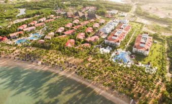 aerial view of a resort surrounded by trees and a beach , with multiple buildings in the background at Bahia Principe Grand la Romana - All Inclusive