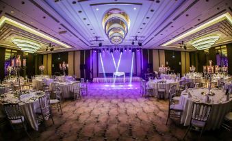 a large banquet hall with multiple tables set up for a formal event , possibly a wedding reception at Doubletree by Hilton Istanbul Umraniye