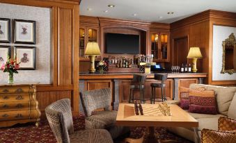 a cozy living room with wooden furniture , including a couch , chairs , and a coffee table at Little America Hotel & Resort Cheyenne