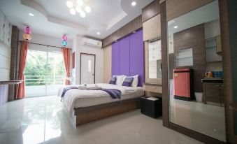 a modern bedroom with purple walls , white bedding , and wooden furniture , including a bed with a white comforter at The Linux Garden Hotel