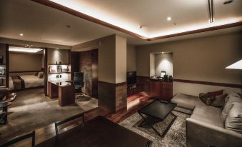 a modern office space with wooden floors , dark walls , and a large window , featuring a conference table , couch , and other furniture at Oarks Canal Park Hotel Toyama