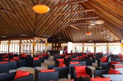 a large , well - lit restaurant with multiple dining tables and chairs arranged in an open space at Vilamendhoo Island Resort & Spa