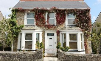 a brick house with ivy climbing up the walls and a white door in front of it at Ocean View