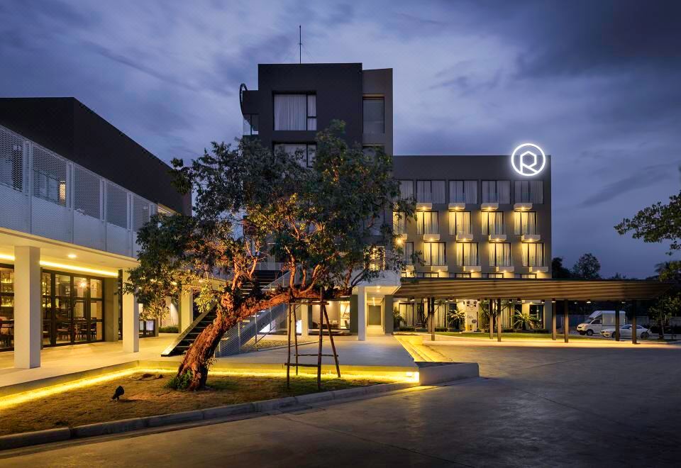 a large building with a tree in front of it and the q logo on top at R Photo Hotel