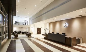 a large , well - lit lobby with a checkered floor and a volkswagen logo prominently displayed at Tulip Inn Itaguai