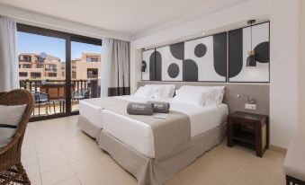a hotel room with two beds , one on the left side and the other on the right side of the room at Barceló Tenerife
