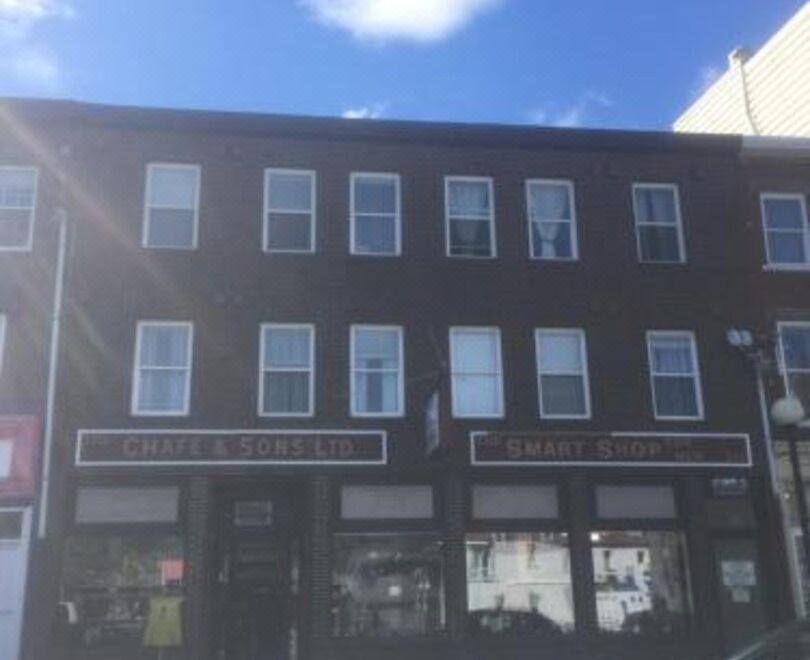 "a brown building with a sign that reads "" coffee & tea "" is shown in the image" at Ashton Apartments