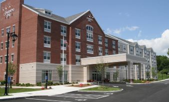 a brick building with a red roof and a white sign is shown from the outside at Hampton Inn Bath (Brunswick Area)