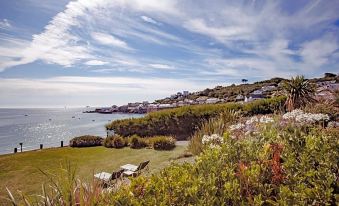 a scenic view of a coastal area with houses , green plants , and the ocean in the background at The Bay Hotel