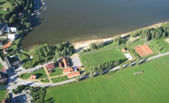 a bird 's eye view of a river , a grassy field , and a building near the water at Hotel Albatros