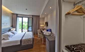 a modern hotel room with a bed , desk , and chair , along with a large window that offers views of the outdoors at Hotel Majestic