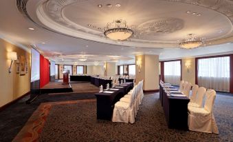 a large conference room with multiple rows of tables and chairs set up for a meeting or event at Hotel Royal