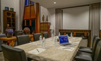 a conference room with a table , chairs , and a laptop , set up for a meeting or presentation at Mae Rim Grace