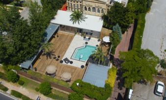 aerial view of a large swimming pool surrounded by trees and buildings in a city at Mikelina Boutique Hotel