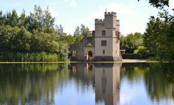 a castle - like building surrounded by trees and a body of water , creating a picturesque scene at Station House Hotel Letterkenny
