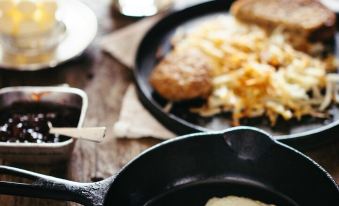 a table with two fried eggs in a black skillet , surrounded by various breakfast items at Heritage Hotel Lancaster