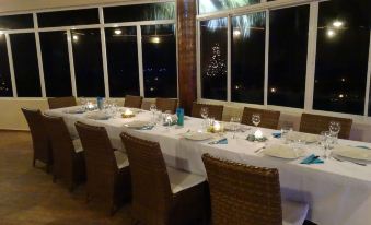 a dining room with a long table set for a formal dinner , surrounded by chairs at Beachcomber at Las Canas