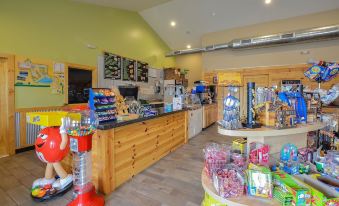 a well - lit convenience store with various snacks and drinks on display , including a candy counter at Sun Retreats Gun Lake