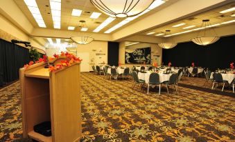 a large conference room with tables and chairs arranged for a meeting or event , featuring a floral centerpiece at Shilo Inn Suites Klamath Falls