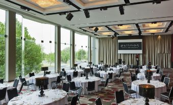 a large dining room with round tables and chairs set up for a formal event , possibly a wedding reception at Pullman Melbourne Albert Park