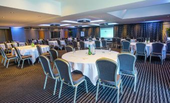 a large conference room with round tables and chairs arranged for a meeting or event at DoubleTree by Hilton Bristol South - Cadbury House