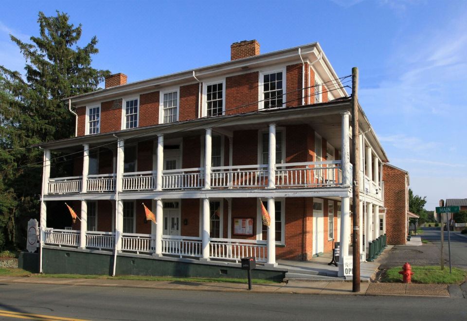 a brick building with multiple balconies and white columns is situated on a street corner at Lafayette Inn