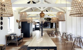 a dining area with a long wooden dining table surrounded by chairs , and a buddha statue hanging from the ceiling at Torre de Palma Wine Hotel, Montforte, a Member of Design Hotels