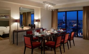 a dining room with a long wooden table surrounded by red chairs , set for a formal dinner at Hyatt Regency Birmingham