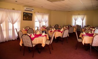 a large dining room with several tables and chairs arranged for a group of people at The Palace Hotel