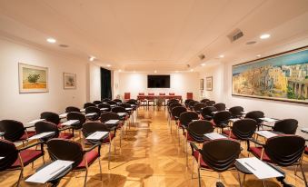 a conference room with rows of chairs arranged in a semicircle , and a podium at the front of the room at Covo dei Saraceni