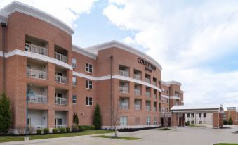 "a large brick building with multiple balconies and a sign that reads "" courtyard suites "" prominently displayed" at Courtyard Columbus New Albany