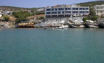 a large building is situated on a hillside overlooking a body of water with boats docked at Argo Spa Hotel