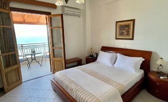a spacious bedroom with a large bed , a window , and a door leading to a balcony at Sofotel