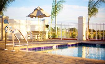 a rooftop pool surrounded by chairs and umbrellas , with a view of the surrounding area at Hampton Inn & Suites Lake Wales