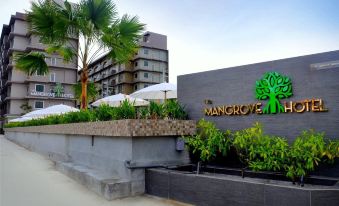 "a large stone building with a sign that reads "" mangrove bay "" prominently displayed on the front of the building" at The Mangrove Hotel