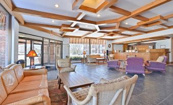 a spacious living room with wooden beams on the ceiling , creating an open and inviting atmosphere at Best Western Prairie Inn  Conference Center