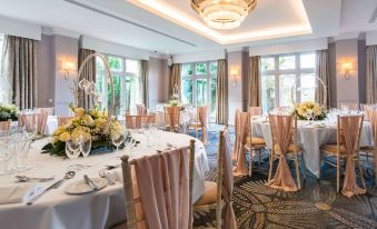 a dining room with tables and chairs set up for a formal event , possibly a wedding reception at Mercure Blackburn Dunkenhalgh Hotel & Spa