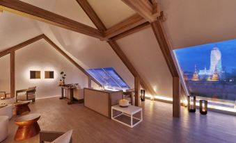 a room with a wooden ceiling and floor , featuring a large window and a triangular structure at Sala Ayutthaya