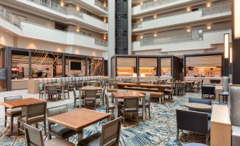 a large hotel lobby with various seating options , including couches and chairs , as well as a dining table at Embassy Suites by Hilton Monterey Bay Seaside