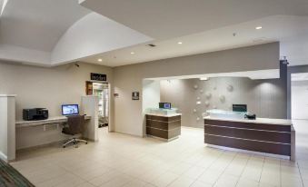 a modern office space with white walls , wooden floors , and a reception area featuring a desk , computer , and other amenities at Residence Inn Stockton