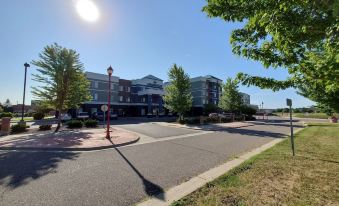 a sunny day in a residential area , with several cars parked on the street and a building in the background at Grandstay Apple Valley