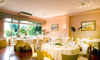 a large dining room with tables and chairs arranged for a group of people to enjoy a meal together at Hotel Continental